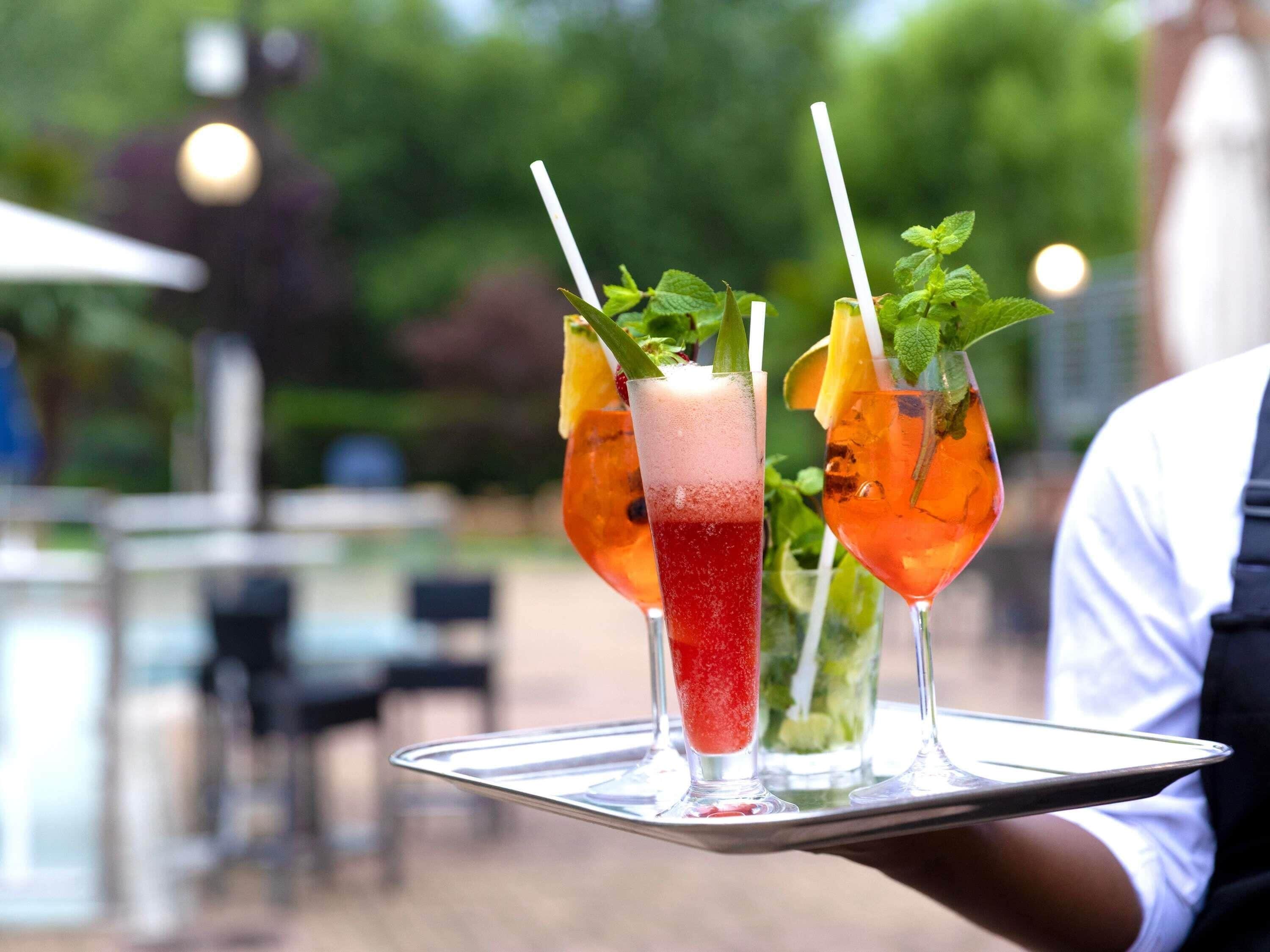 A tray with three drinks, each garnished with a mint leaf and a straw.