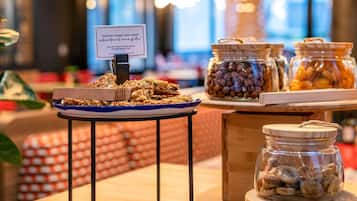 Una mesa de buffet con granola, nueces y frutas secas.
