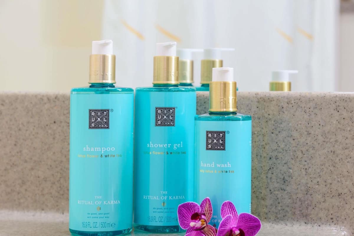 Drei Flaschen der Rituals Karma-Produktlinie auf einer Arbeitsplatte mit Marmoroberfläche.