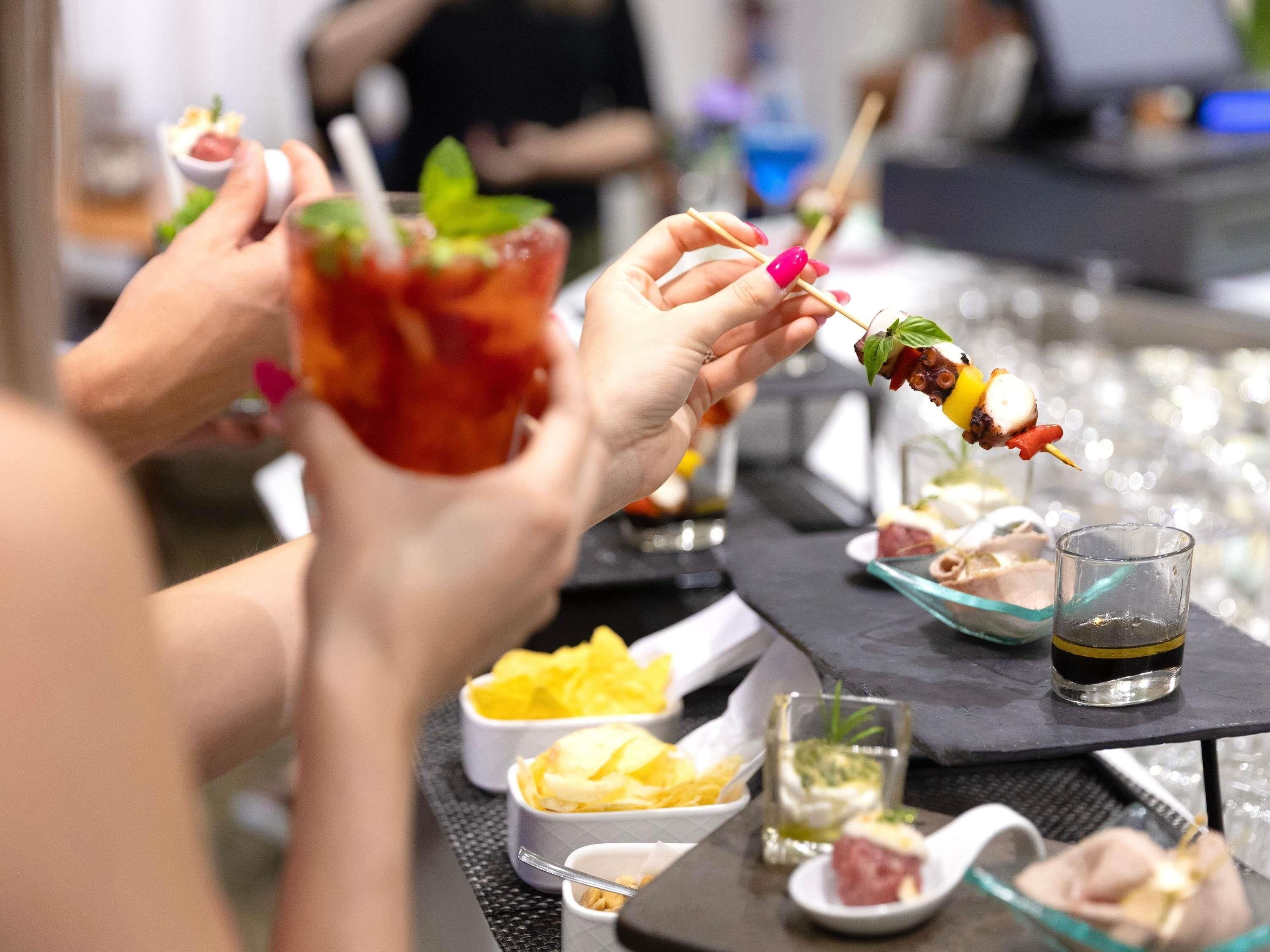 Un espace bar proposant une variété de plats et de boissons, notamment des brochettes et de petites portions.