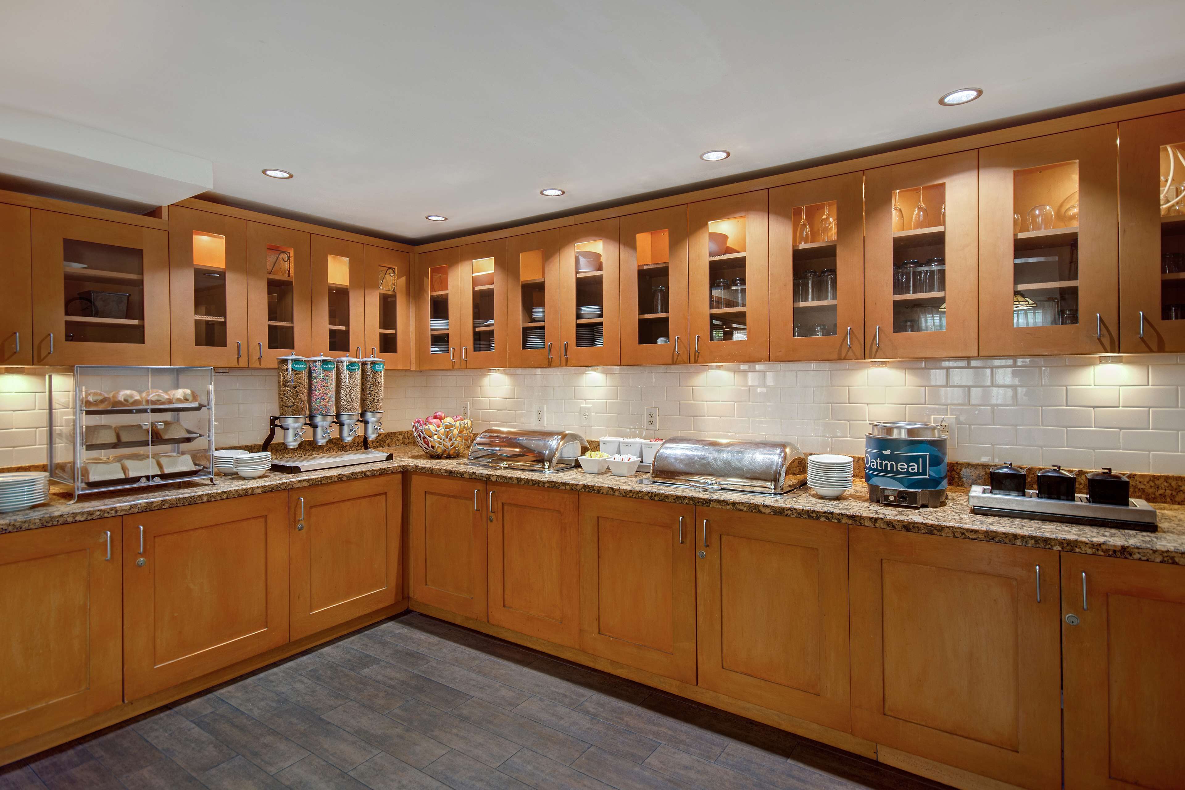 Una cocina moderna con armarios de madera, encimera de granito y electrodomésticos como cafetera y tostadora.