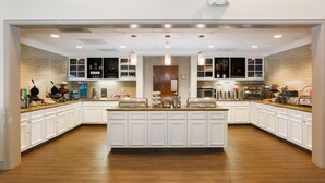 A spacious kitchen with white cabinetry, a central island, and pendant lighting. - Homewood Suites Southwind - Hacks Cross (Memphis)