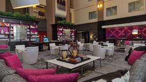A spacious lobby with multiple seating areas, a reception desk, and a well-stocked library. - Le Meridien Dallas by the Galleria (Dallas)