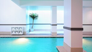 A swimming pool area with a clear view of the pool, a potted plant, and a seating area with towels. - Le Meridien Dallas by the Galleria (Dallas)