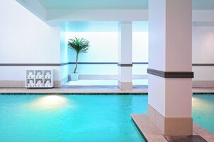 Una piscina cubierta, tumbonas