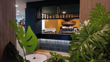 A bar area with shelves of bottles, a coffee machine, and a counter.