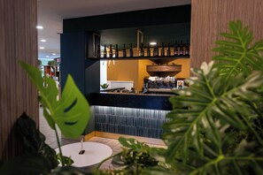 A bar area with shelves of bottles, a coffee machine, and a counter.