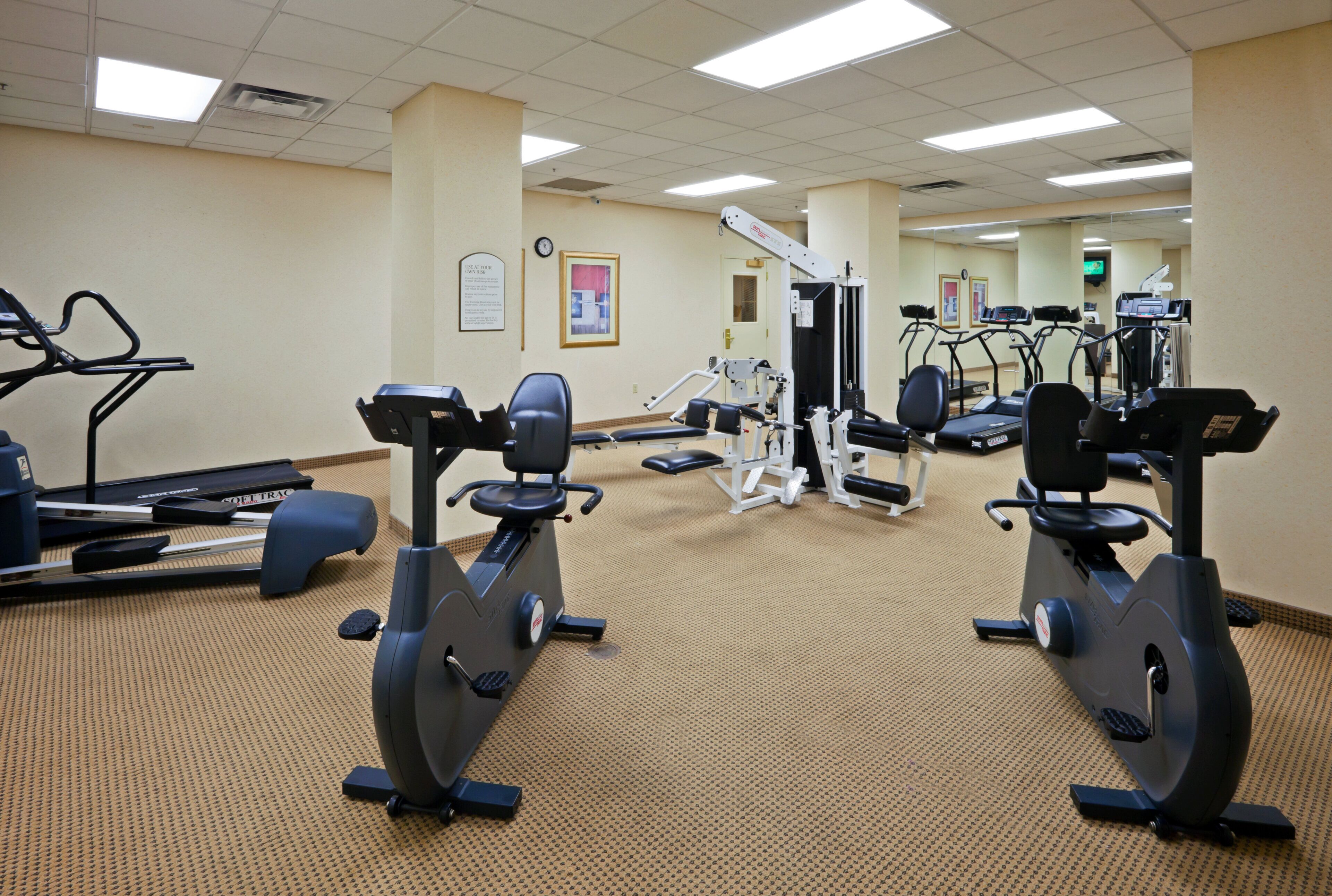 A gym with stationary bikes, treadmills, and weight machines.