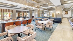 A spacious dining area with multiple tables and chairs, a bar, and a seating area with couches. - Holiday Inn Chantilly - Dulles Arpt Area by IHG (Chantilly)