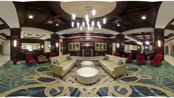 A spacious lobby with a central seating area, a reception desk, and a fireplace. - Holiday Inn Chantilly - Dulles Arpt Area by IHG (Chantilly)