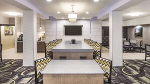 A conference room with a long table, chairs, a flat-screen TV, and a modern ceiling design. - La Quinta Inn & Suites by Wyndham Milledgeville (Milledgeville)