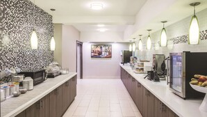 A modern kitchen with two sinks, a microwave, and a refrigerator. - La Quinta Inn & Suites by Wyndham Milledgeville (Milledgeville)