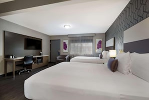 A hotel room with two beds, a desk with a chair, a TV, and artwork on the walls. - Sunset West Hotel, Surestay Collection By Bw (Los Angeles)