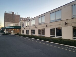 Un edificio de dos pisos con un toldo verde que dice "ROOSEVELT INN Lobby".