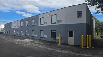 Un edificio moderno con fachada plana, varias ventanas y una puerta.