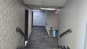 A corridor with a tiled floor leading to a door at the end.