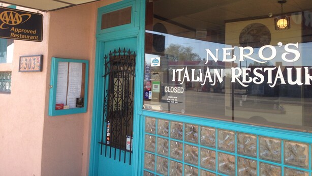 A restaurant with a turquoise door and window, a sign indicating it is an approved restaurant, and a closed sign on the window. - National 9 Inn Sand Canyon (Cortez)