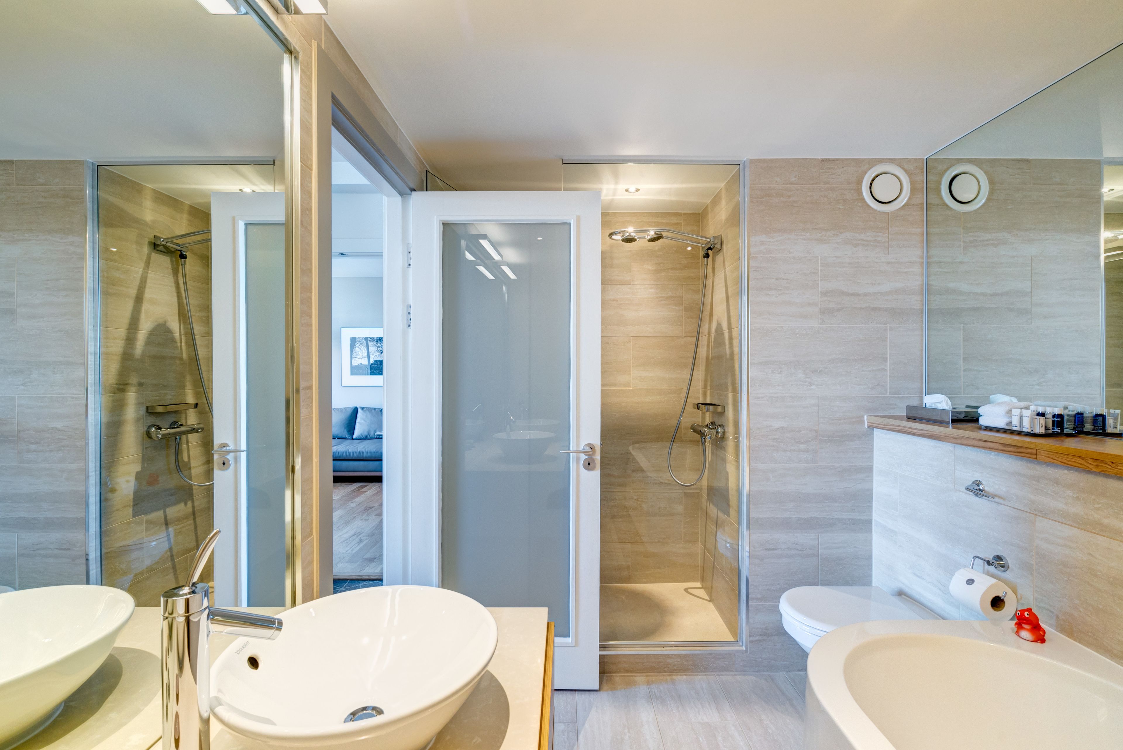 Une salle de bain moderne avec un grand lavabo blanc, une baignoire et une douche à parois de verre.