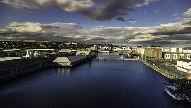 A harbor with industrial buildings, a bridge, and a boat docked. - Apex City Quay Hotel & Spa (Dundee)