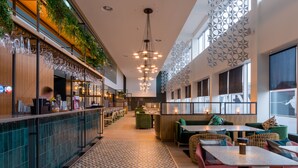 A modern restaurant interior with a bar area, seating, and decorative lighting. - Apex City Quay Hotel & Spa (Dundee)