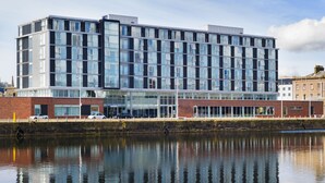 A modern multi-story building with large windows and a reflection in the water. - Apex City Quay Hotel & Spa (Dundee)
