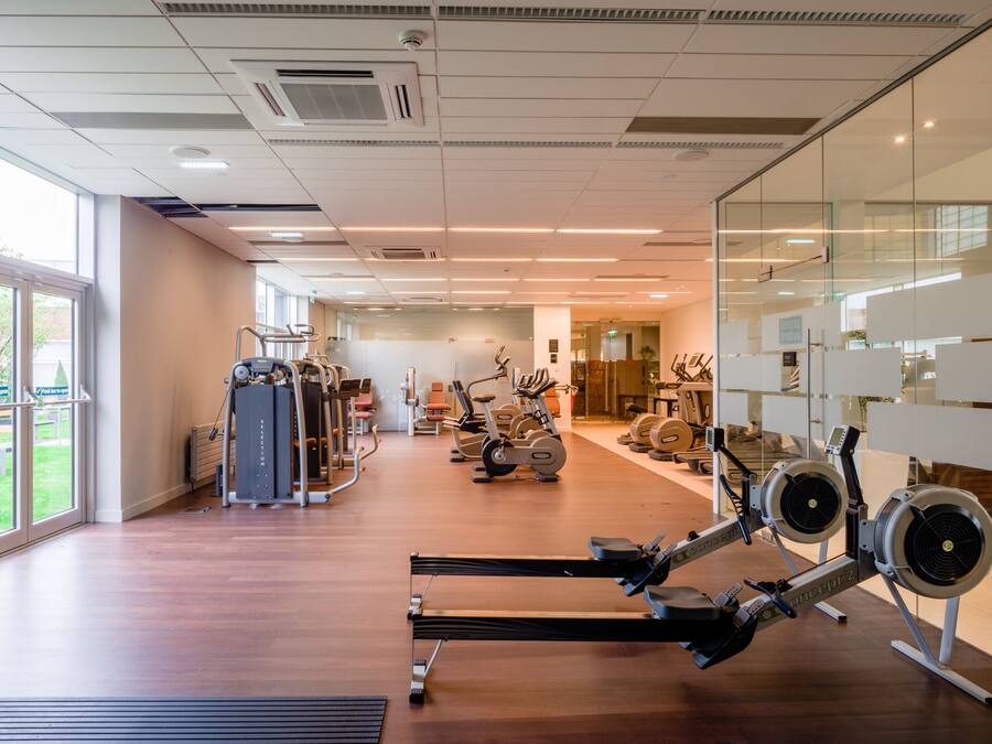 A gym with various exercise equipment, including treadmills, stationary bikes, and weight machines.