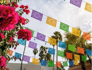 A view of a building with colorful paper decorations strung across the sky. - Hotel Valencia Riverwalk (San Antonio)