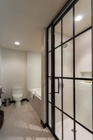 Un baño moderno con inodoro, cabina de ducha e lavamanos.
