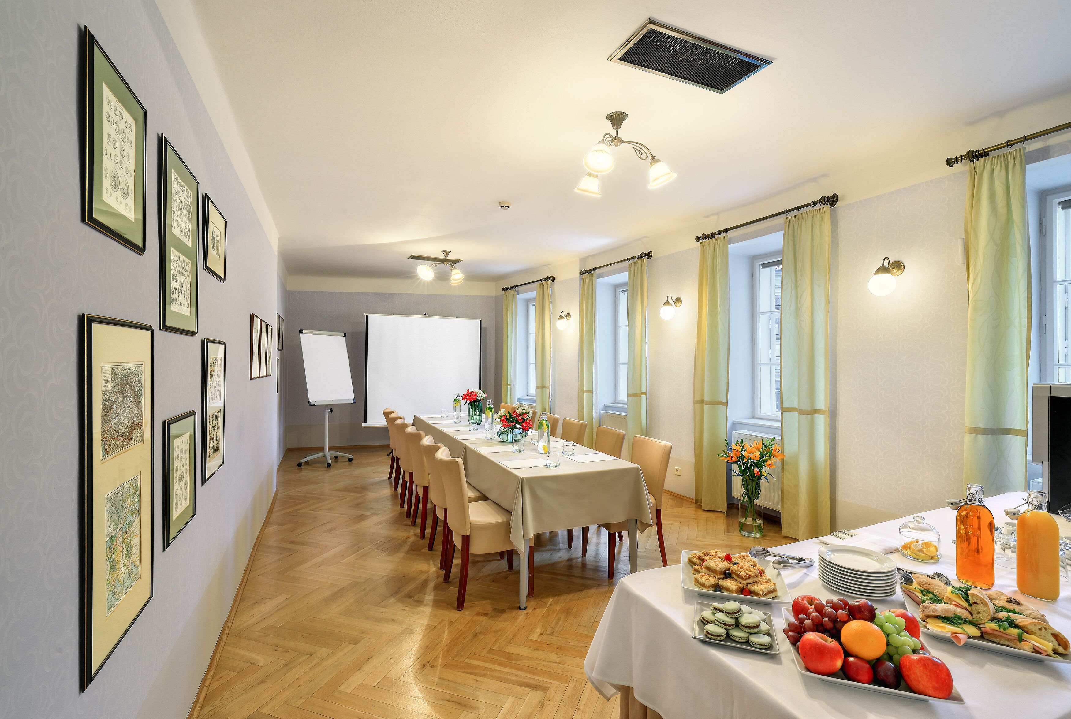 A conference room with a long table, chairs, a whiteboard, and a buffet table with various food items.