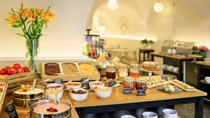 Een buffet met verschillende soorten eten en een vaas vol bloemen.