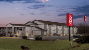 A Red Roof Inn with a two-story building, a parking lot, and a well-maintained lawn.