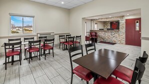A restaurant with tables and chairs, a view through a window, and a Red Roof sign.