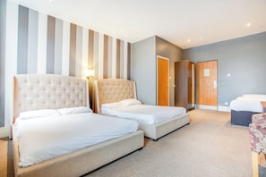 Habitación familiar, varias camas (Deluxe) | Escritorio y ropa de cama