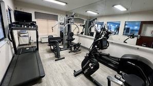 A gym with cardio machines, weight training equipment, and a mirrored wall. - Quality Inn & Suites, Near University (Waco)