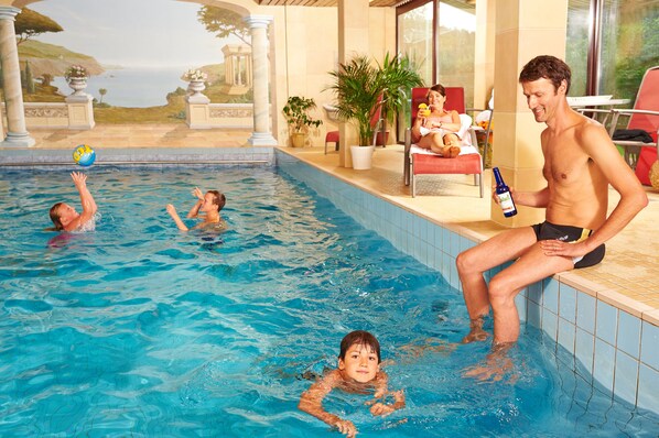 Una piscina techada, sillones reclinables de piscina