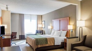 A hotel room with a bed, a desk, a chair, a sofa, and a TV. - Comfort Inn & Suites West Chester - North Cincinnati (West Chester)