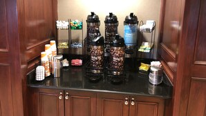 A coffee station with multiple coffee makers and a variety of coffee pods. - Comfort Inn & Suites West Chester - North Cincinnati (West Chester)