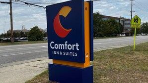 A Comfort Inn & Suites sign with a large logo, located beside a road with a school crossing sign visible. - Comfort Inn & Suites West Chester - North Cincinnati (West Chester)