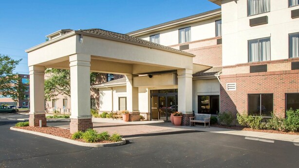 A hotel entrance with a covered waiting area, a brick facade, and a clear sky. - Comfort Inn & Suites West Chester - North Cincinnati (West Chester)
