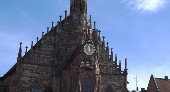 Una iglesia histórica con una destacada torre de reloj y elementos arquitectónicos góticos.