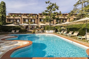 Una piscina al aire libre de temporada, sombrillas