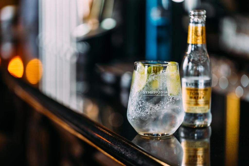 A bar setting with a glass labeled 'SYMPHONIA' and a bottle of 'EVERLAST' whiskey.