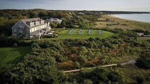 A large house with a well-maintained lawn and a golf course nearby. - The Wauwinet (Nantucket)