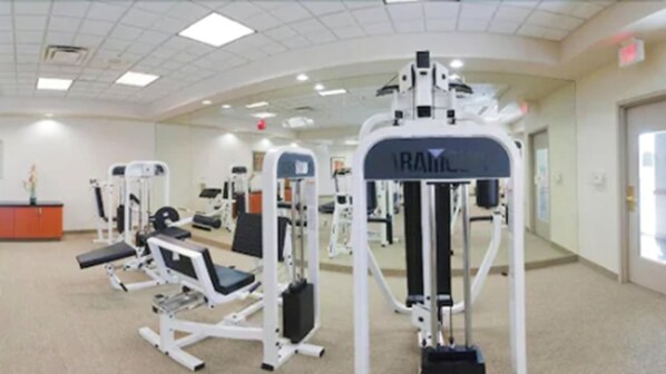 A gym with various exercise machines, a bench, and a mirrored wall. - Holiday Inn & Suites Goodyear - West Phoenix Area by IHG (Goodyear)