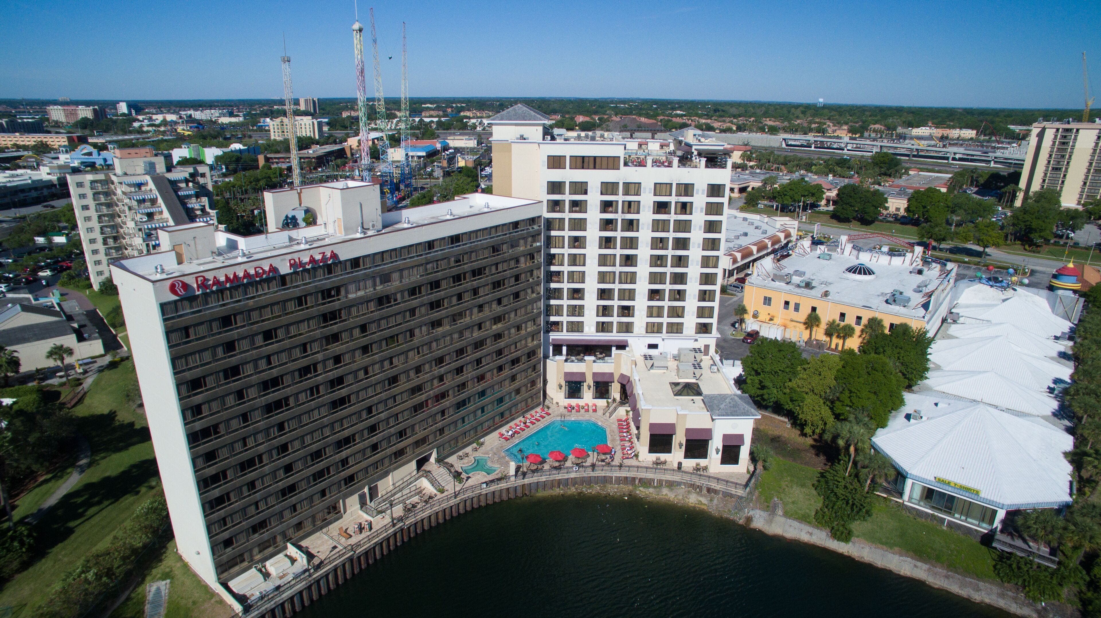 Et hotel med pool, flere etager og udsigt over byens skyline.
