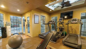 A gym with treadmills, an elliptical, a stationary bike, and a rowing machine.