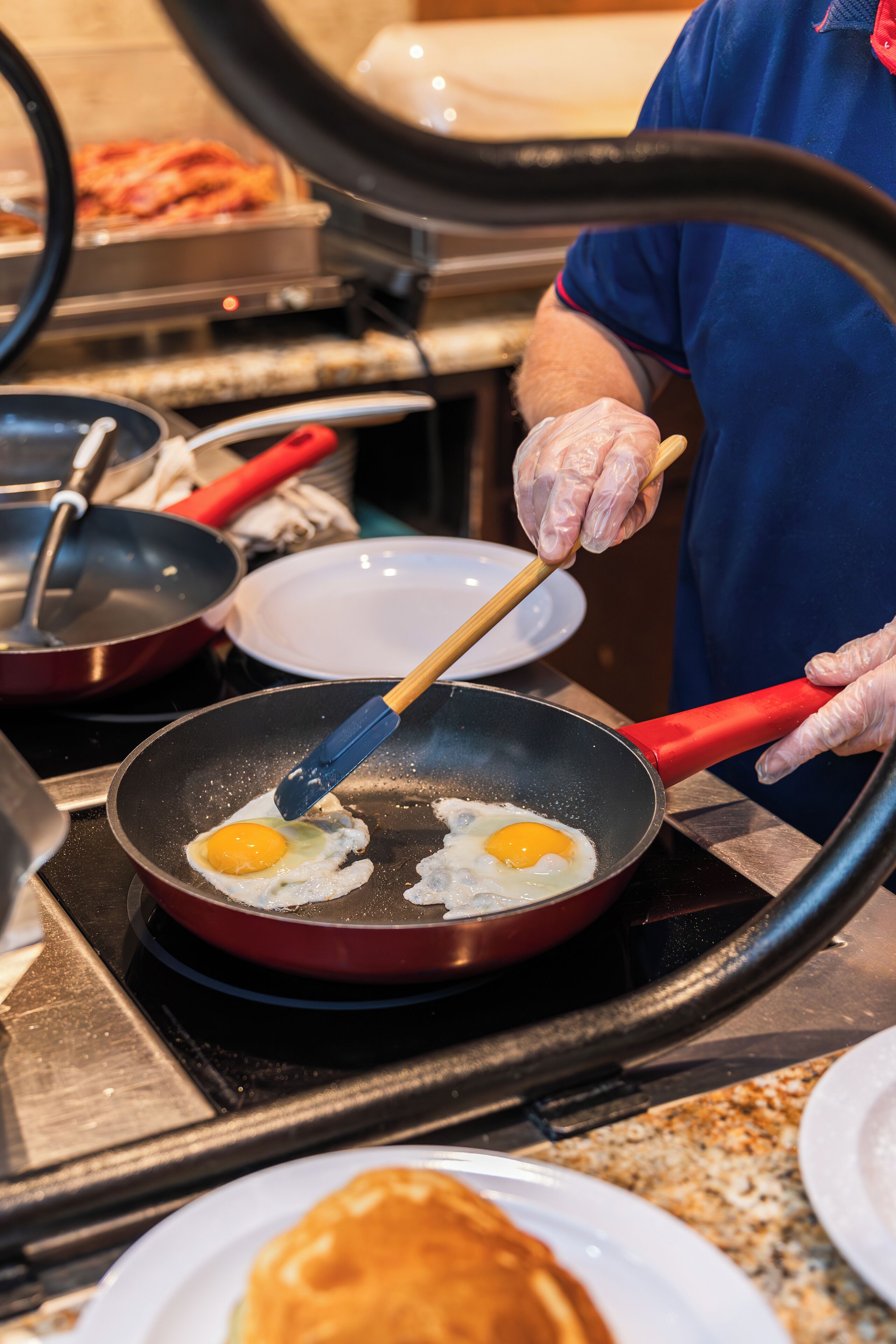 Une personne qui prépare des œufs dans une poêle sur une cuisinière.