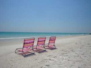 Vlak bij het strand, wit zand, ligstoelen aan het strand, strandlakens