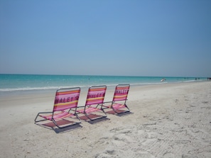Vlak bij het strand, wit zand, ligstoelen aan het strand, strandlakens