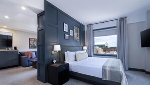 Une chambre d’hôtel moderne équipée d’un grand lit, d’un bureau, d’une chaise et d’un téléviseur.